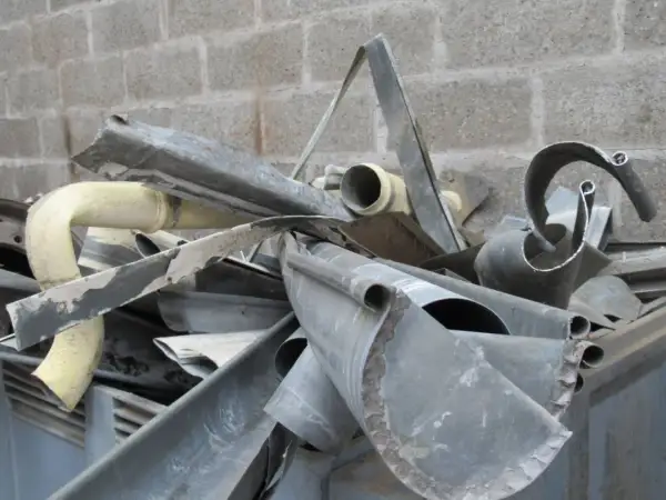 Tas de gouttières et tubes métalliques tordus. Comment reconnaître un métal ? Observez sa texture, sa couleur et sa forme.