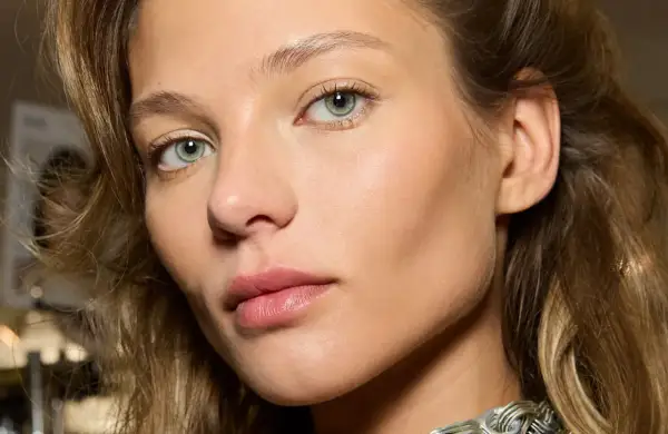 Un visage de femme aux yeux verts, peau lumineuse. Comment reconnaître du bronze ? La peau de ce modèle a un éclat naturel, comme si elle était hâlée par le soleil.